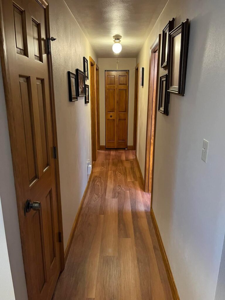 Residential Hallway with Stained Floor & Doors
